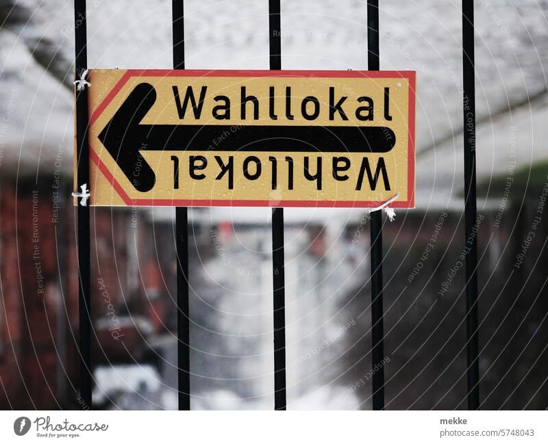 Turning the election on its head polling station Fence Grating sign Arrow cordon Signage Barrier tethered makeshift choice Signs and labeling Election campaign