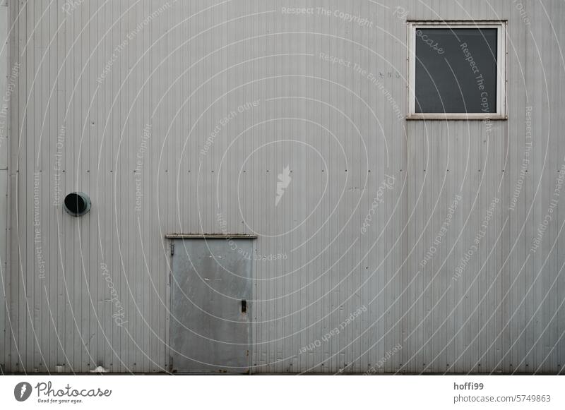 gray, dull, dilapidated industrial façade with door, window and ventilation outlet Industrial plant Window ventilation pipe Facade Gray Gloomy dreariness dirt