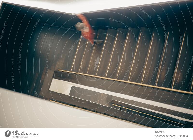 a blurred young person walks down a flight of stairs Staircase (Hallway) Stairs Downward Descend Going go down downstairs Banister rail