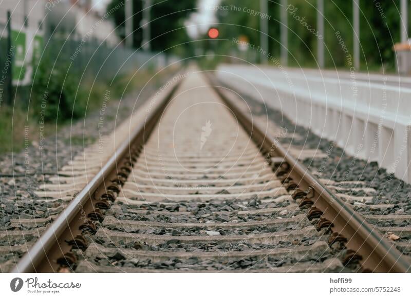 Straight ahead on the track bed with a red signal light in the distance - the destination is in the way Rail transport Railroad system Railroad tracks rail