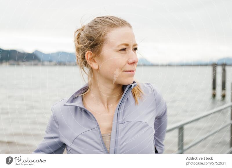 Active woman pausing by the sea during a workout active fitness pause tranquil contemplative ocean view seaside break enjoy reflecting fitness routine healthy