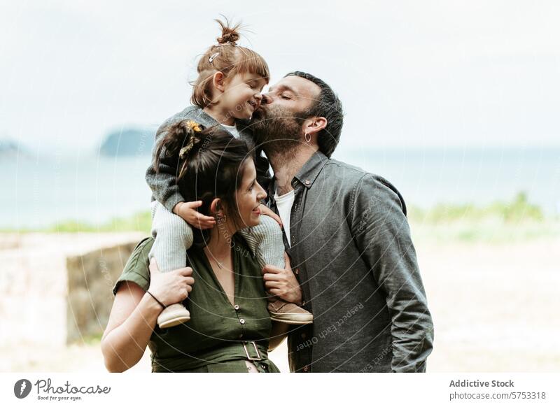 Family affection at the beach: moments of love and care family father mother daughter kiss outdoors summer bonding relationship portrait child parent