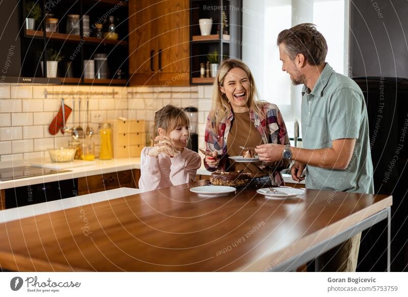 Joyful Family Enjoying Homemade Chocolate Cake in Cozy Kitchen family chocolate cake homemade kitchen enjoying dessert bonding smiles laughter cozy sunlit