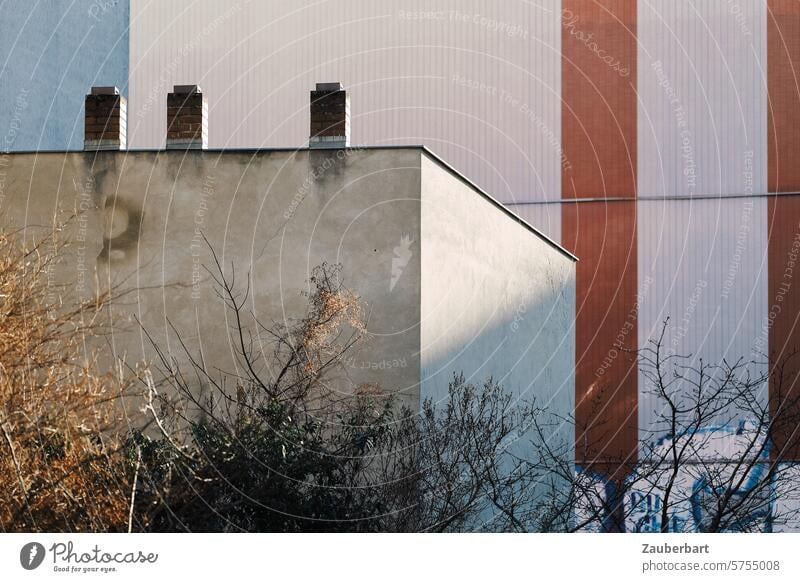 Facades, color stripes and three chimneys form an abstract ensemble, with branches and trees in front of them Abstract Stripe Building Concrete structures