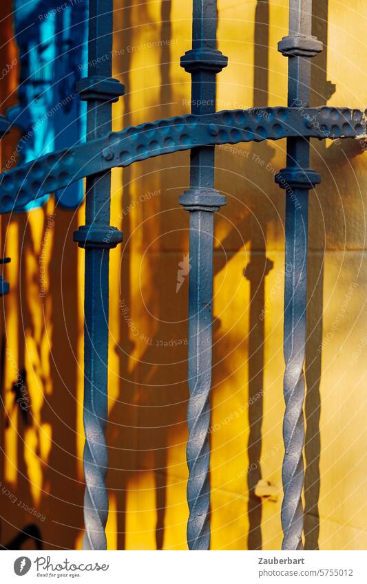 Wrought-iron gate casts shadows on yellow wall, close-up Goal forged Iron wrought-iron Shadow shadow cast Wall (building) Yellow Old Historic Metal door Detail