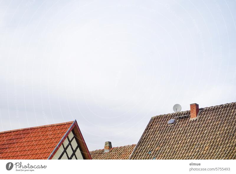 Tiled roofs with chimneys, a satellite dish, a skylight and a half-timbered gable pediment Chimney Roof Satellite Dish Village dwell Roofing tile Blog Skylight