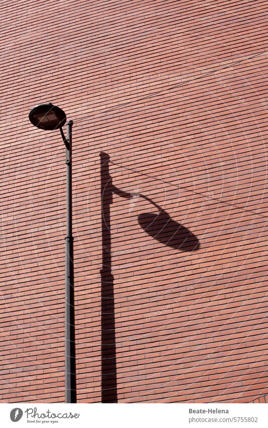 Illuminated luminaire in Paris Street lighting Shadow Brick wall Wall (building) Wall (barrier) Exterior shot Deserted Facade Structures and shapes Architecture