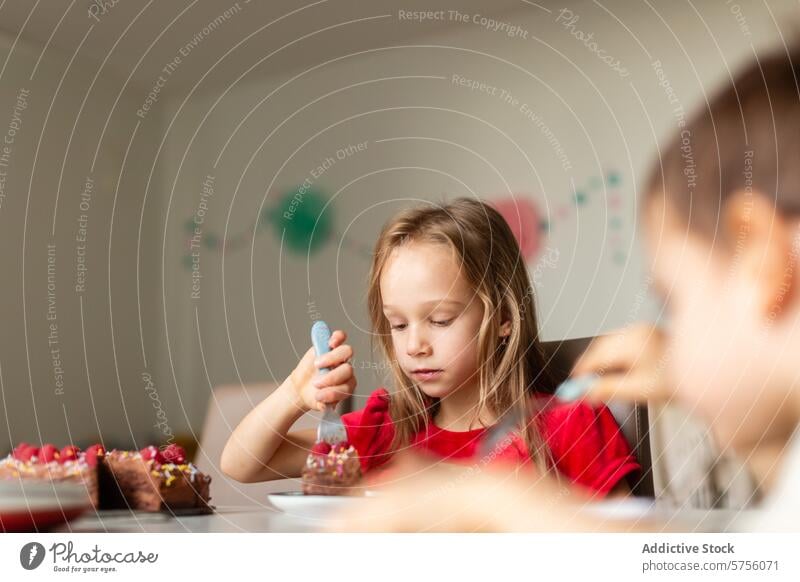 Girl enjoying a slice of birthday cake at home girl eating party celebration child dessert table decoration happiness focused domestic red top indoor plate