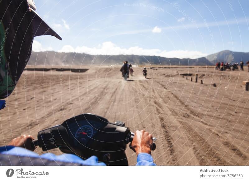 Adventure riding in the sands of Indonesia indonesia adventure motorbike sandy landscape travel tourism outdoor ride sky clear distant rider dusty trail