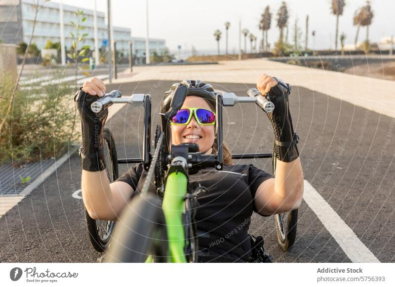 Paralympic athlete training on handbike paralympic female determination sport smile adaptive equipment wheelchair cheerful racing fitness outdoor competition