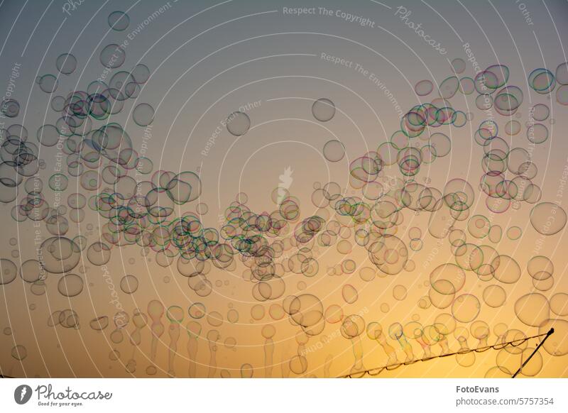 Lots of soap bubbles in the sky at sunset with soap bubble stick balls abstract rainbow colors liquid background orange air bubble Soap bubbles Colorful device