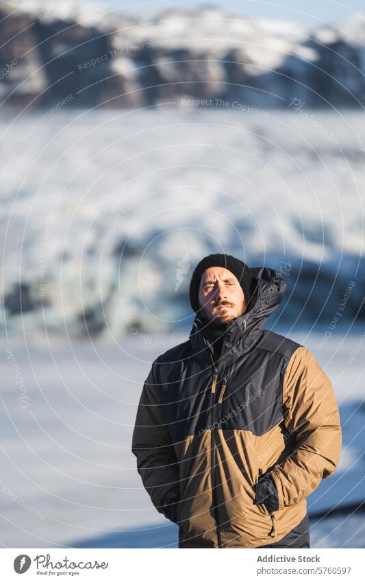 An adventurer in warm winter gear looks on thoughtfully at the expansive glacial landscape that unfolds in the heart of Iceland explorer man cold nature outdoor