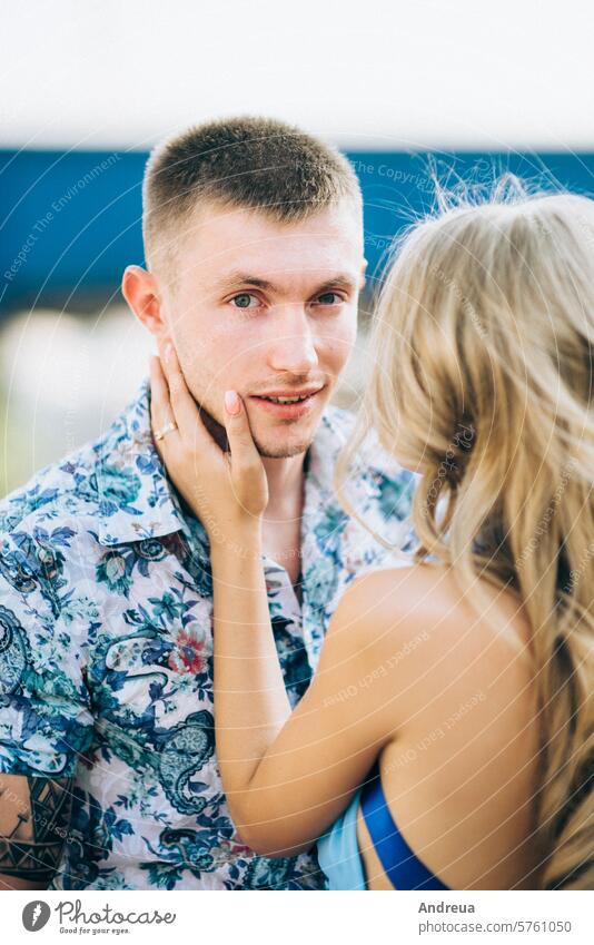 blonde girl in a light blue dress and a guy in a light shirt in a granite quarry boyfriend young teenager for a walk together gravel heap gray sand mountains