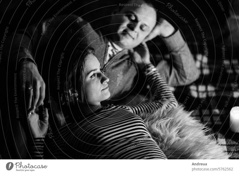 guy and girl are sitting on the background of a burning fireplace boy house inside home young couple in the background evening dark cozy warm family together