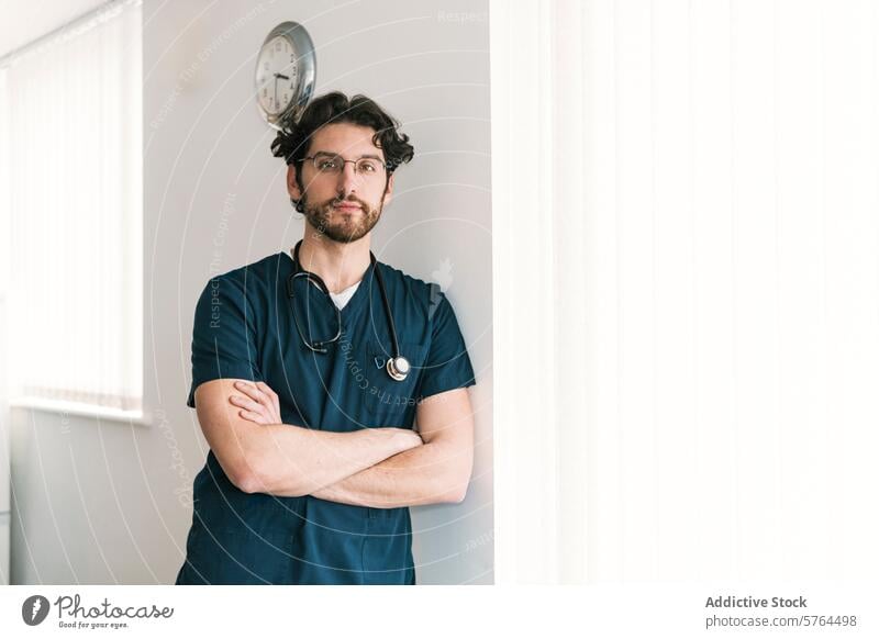 A pensive male healthcare worker with arms crossed stands by a clock, symbolizing timely medical services professional scrubs stethoscope doctor nurse