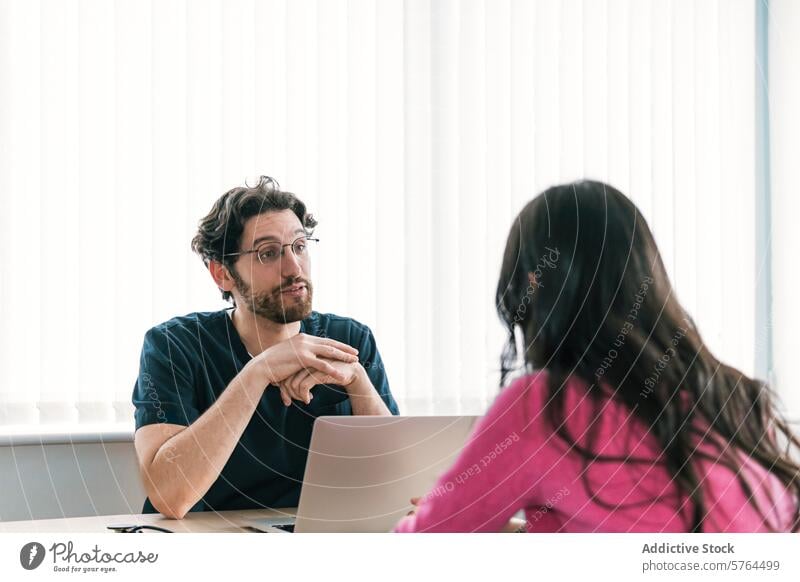 A friendly male doctor in scrubs is in a consultation, offering listening ear and advice to anonymous patient healthcare medical professional engaged clinic