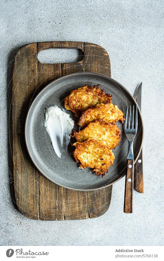 Crispy potato american pancakes with sour cream on wooden tray potato pancake overhead view gray plate rustic wooden background golden brown fried crispy food