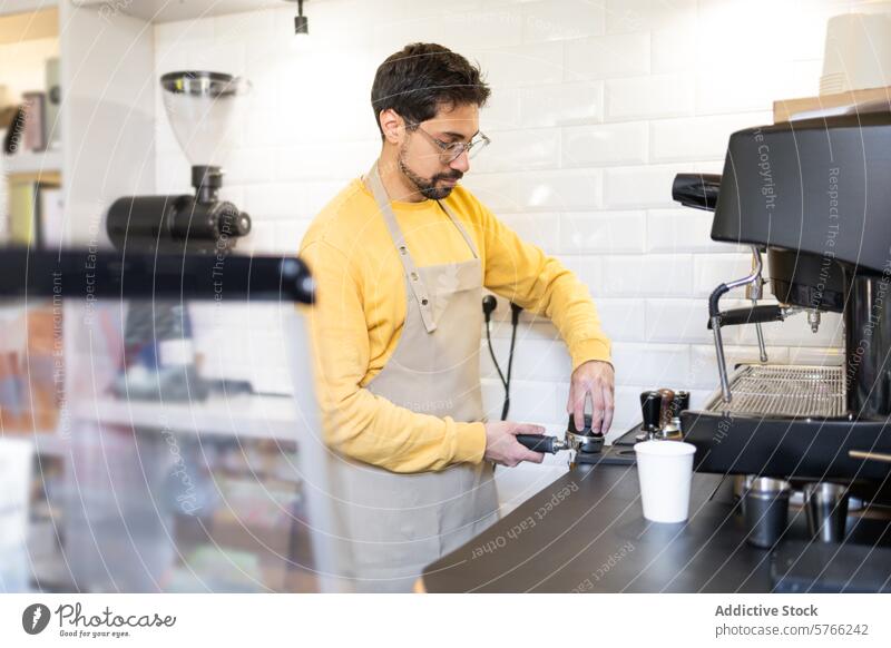 Barista preparing coffee at espresso machine in cafe barista man preparation beverage drink service industry hospitality worker job profession apron focus