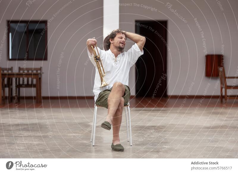 Inspirational one-armed trumpeter practicing outdoors hobby man resilience determination passion music instrument gold chair sitting summer hat white shirt