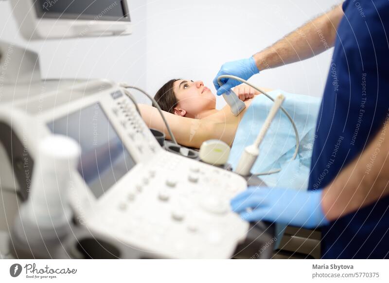 Mammologist doctor examines a woman breasts and lymph nodes using ultrasound. Mammography and ultrasound scanning are main methods of instrumental diagnosis of mammary glands. Breast cancer