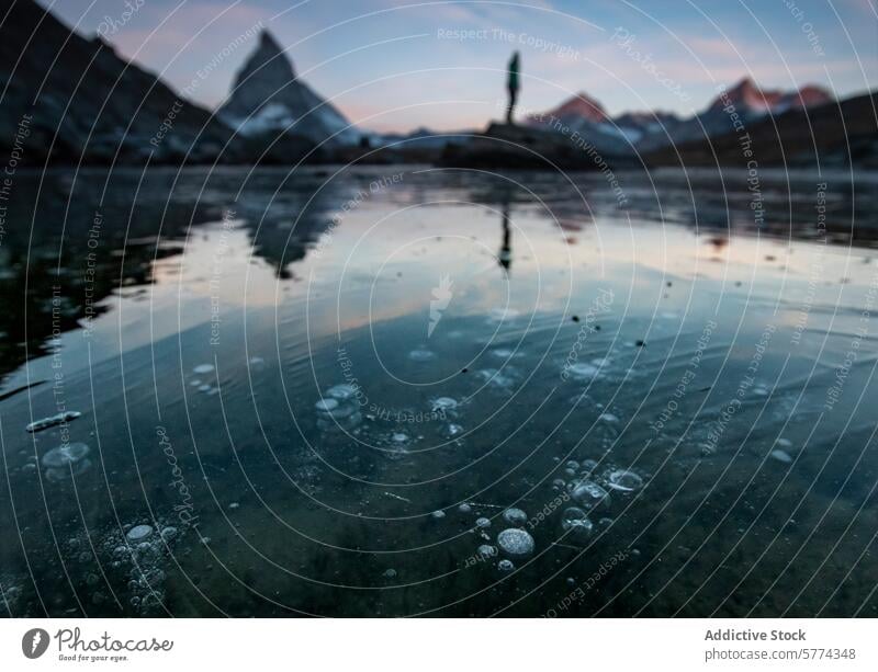 Spring Thaw at Matterhorn's Lakeside spring matterhorn swiss alps lake thawing ice person mountain landscape nature outdoors sunrise sunset water alpine peak