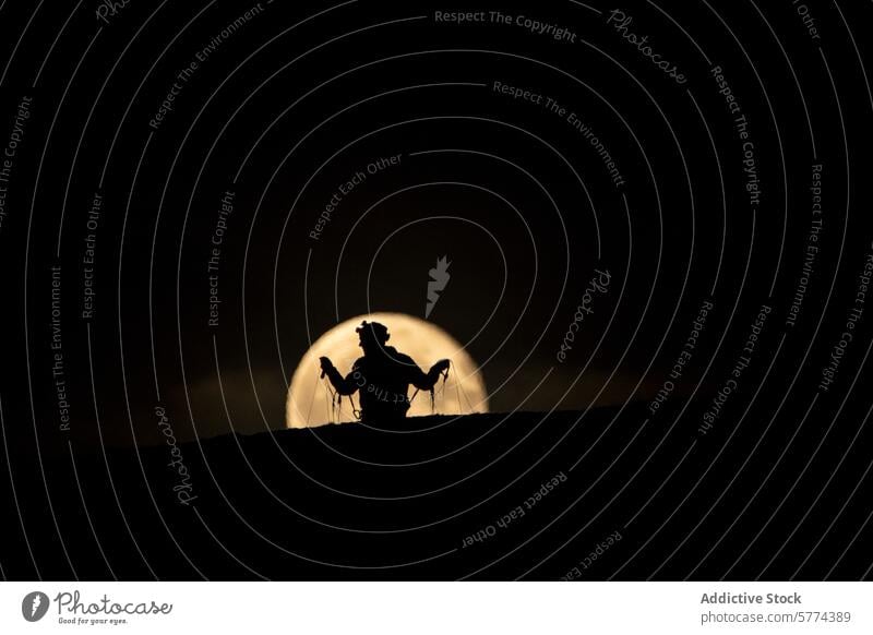 Silhouette of a cowboy against a full moon at Matterhorn silhouette night matterhorn nature landscape dark sky glow western lasso outdoors adventure dusk