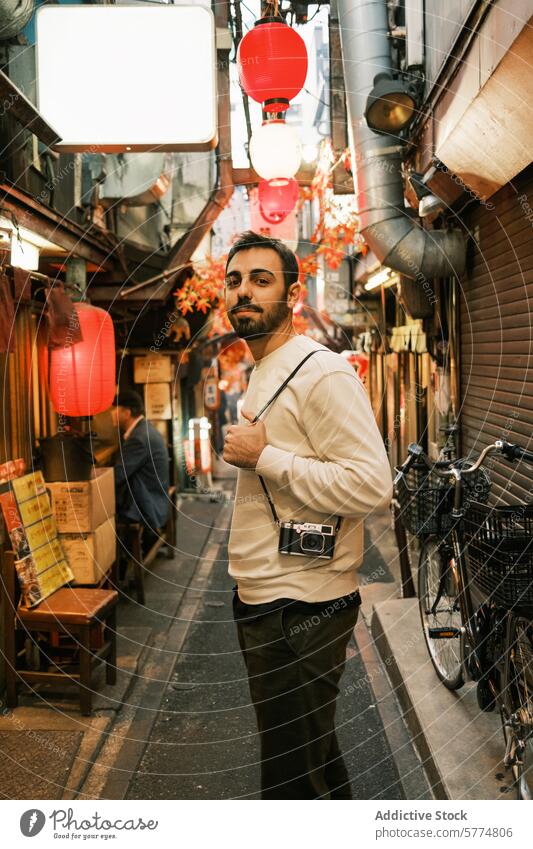 Man with camera wanders in a Japanese lantern-lined alley traveler japan red traditional exploration culture sightseeing tourism journey adventure city street