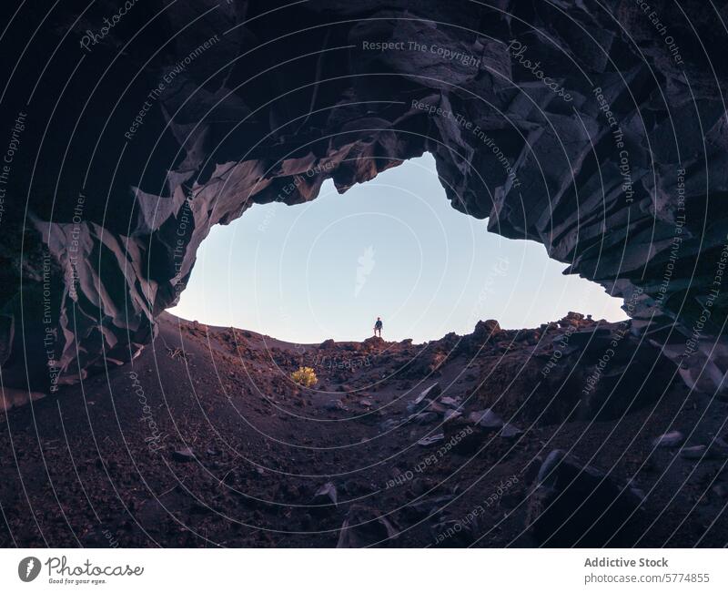 Adventurer standing at cave entrance on La Palma Island la palma island spain explorer volcanic terrain clear sky dusk adventure travel nature landscape rugged