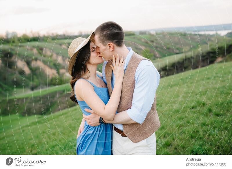 young couple a guy and a girl are walking in the mountain hills green spring summer love together forever blue dress vest brown against the background