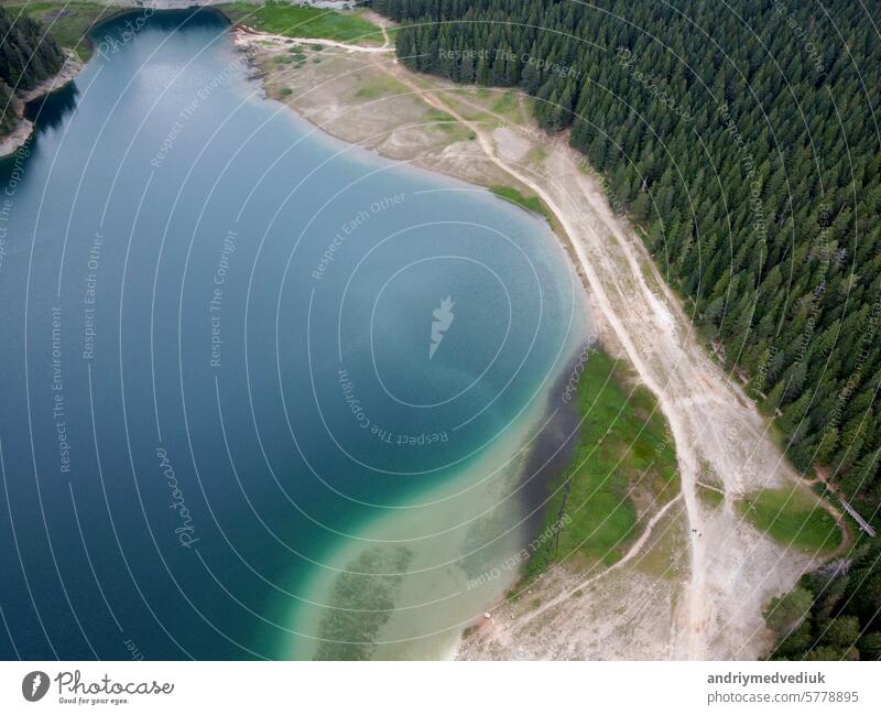 Amazing aerial drone view of Crno Jezero or Black lake, pine forest and cliffs in Durmitor national park, Zabljak, Montenegro. Travel, environment, beauty in nature, relaxing. UNESCO World Heritage