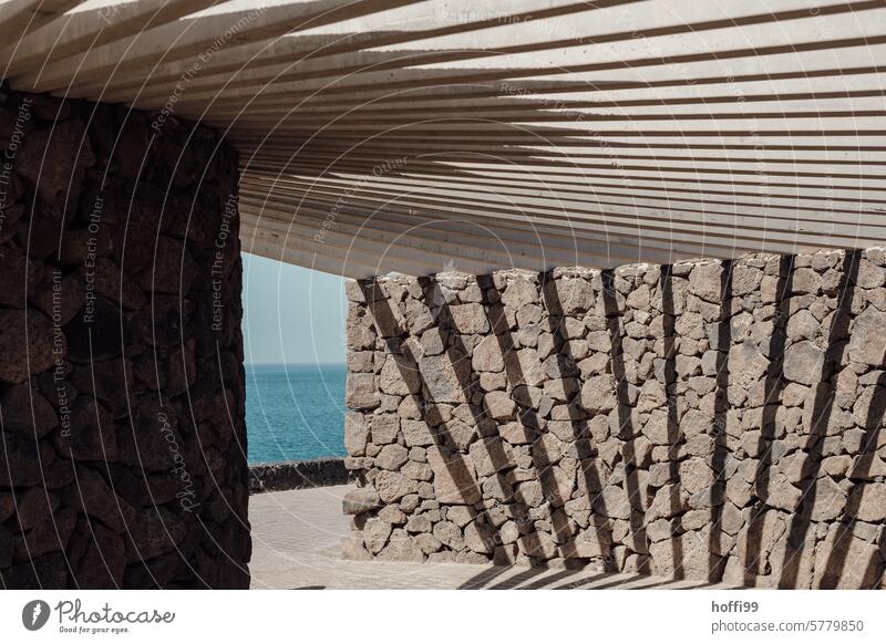 Shadow play of a sunshade on a waterfront promenade Abstract Architecture Light sun protection Light and shadow Pattern Light and shadow play Shaft of light