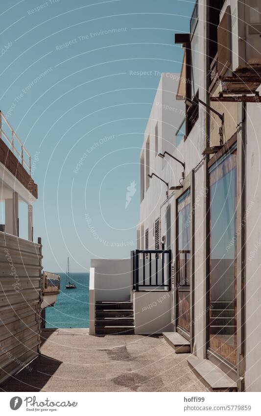 View through an alley onto a sailing boat in the sea Mediterranean ocean Atlantic Ocean Canary Islands Summer Light Canaries canary island Spain Alley