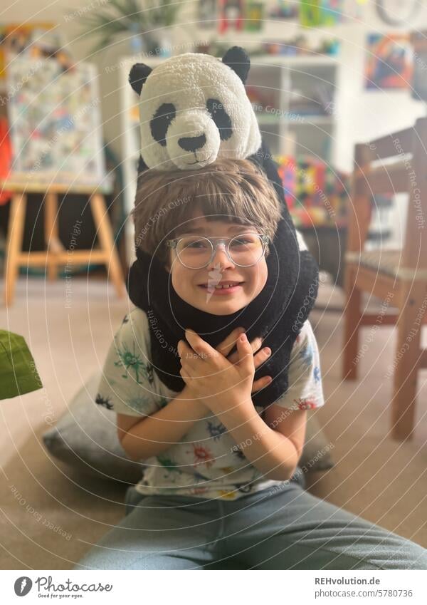 Child with a panda cuddly toy Boy (child) Schoolchild portrait indoors Contentment naturally contented Living room Creativity pedagogy upbringing Human being