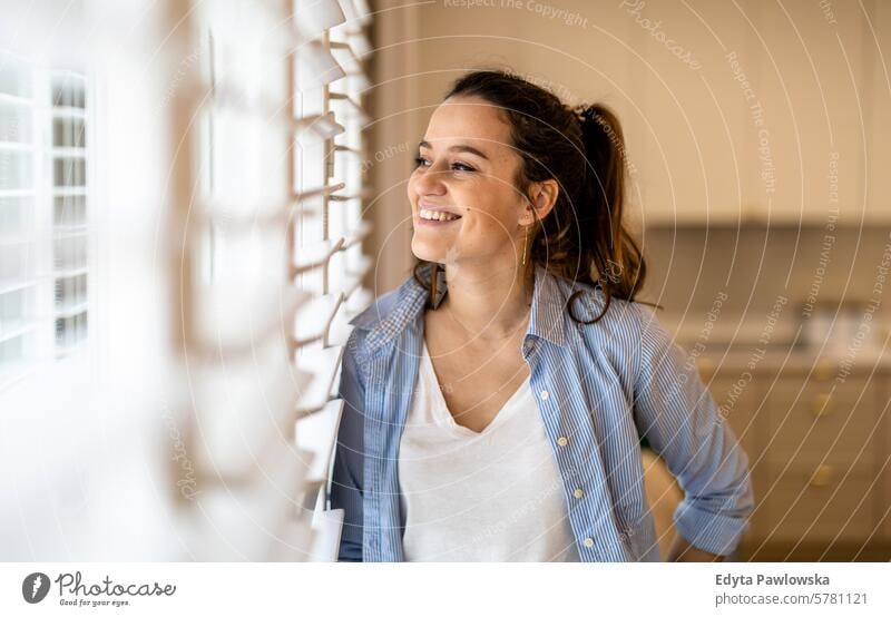 Portrait of a beautiful young woman standing in the kitchen at home people one person room living room adult young adult indoors apartment lifestyle happy