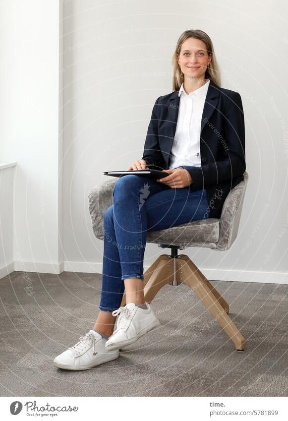 Woman in a seminar room Swivel chair sneakers Room Smiling Jacket Businesswomen Jewellery Armchair Long-haired Looking into the camera Blonde portrait Feminine