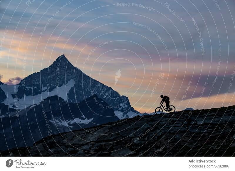 Mountain biking at dusk with beautiful alpine backdrop mountain cyclist summer adventure outdoor activity nature sunset silhouette terrain rocky travel leisure