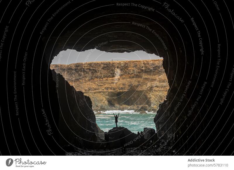 Anonymous woman Celebrating Adventure in Fuerteventura Cave silhouette celebration cave adventure hiking camping fuerteventura canary island spain coast rugged