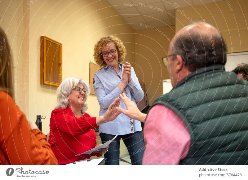 Senior students enjoying a group learning activity senior class education joyful handshake smiling adult education classroom engagement interaction team