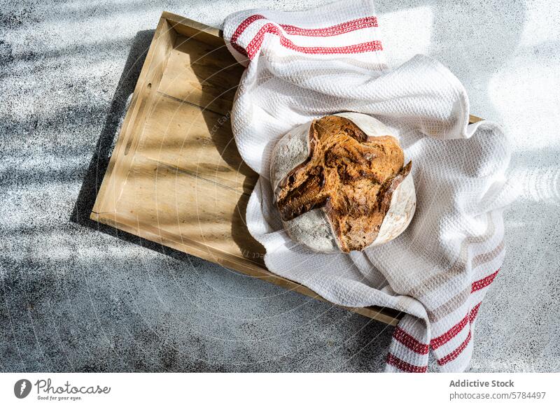 Fresh sourdough rye bread on a rustic wooden tray artisanal towel textured background fresh bakery homemade healthy food whole grain natural fiber nutrition