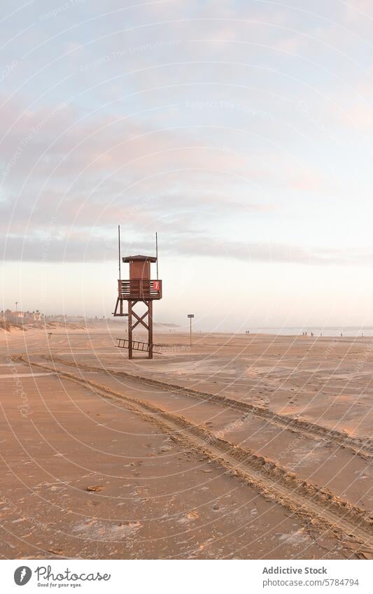 Serene beach scene with empty lifeguard tower at dusk tranquil sand pastel sky serene off-season coastline sunset peaceful calm solitude safety ocean shore