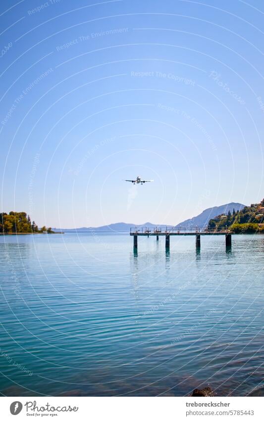 Landing approach of an airplane flying low over a bay to the airport of Corfu travel Tourism Airplane flight Sky Airline Ocean Close Near Kerkyra Greece