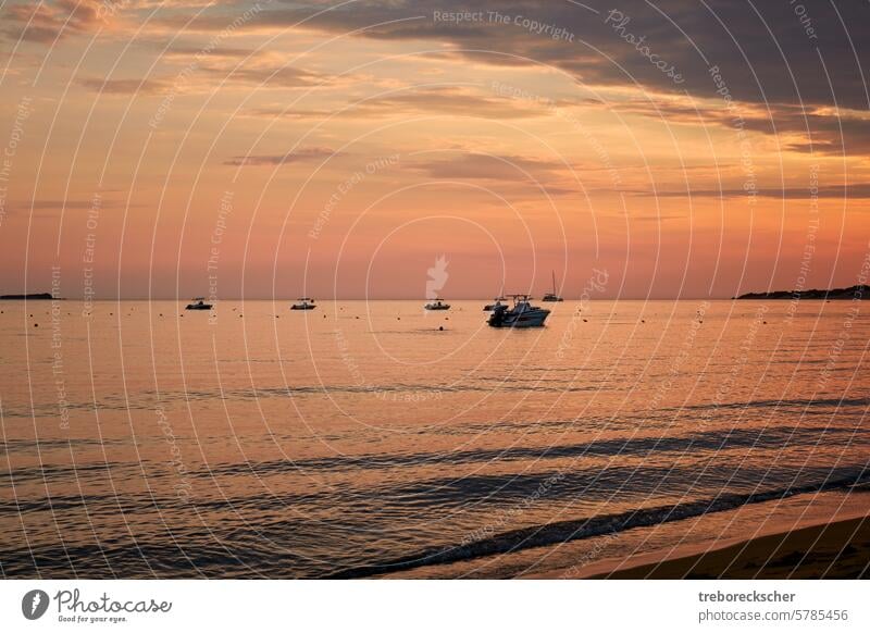 Boats on the west coast of Corfu in the orange blue evening light fishing boats afterwork sunrise sunset ocean sea water tourism anchored travel bay sailboat