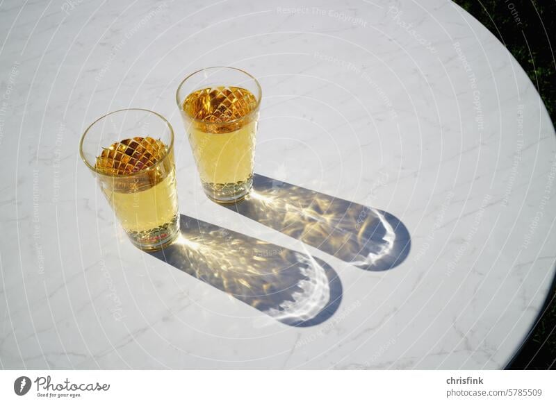 Apple cider glasses stand in sun on white table and cast shadow Apple Cider Apple juice Äppler Frankfurt bottle Ribbed Beverage Drinking Glass Alcoholic drinks