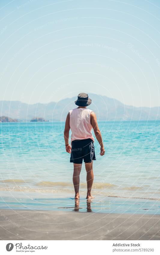 Man enjoying peaceful beach walk in Costa Rica man costa rica serenity tranquility nature shore sand water ocean sea summer travel tropical coastline landscape