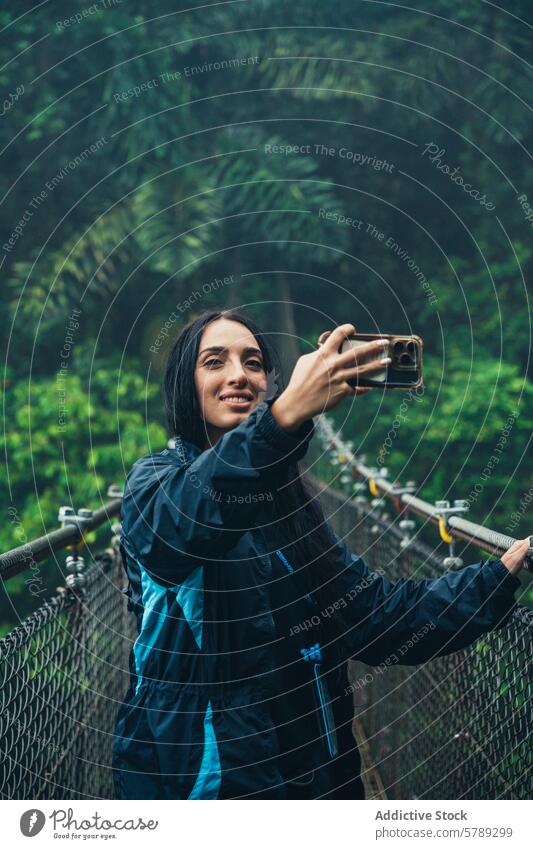 Woman Taking Selfie on Suspension Bridge in Costa Rica woman selfie suspension bridge costa rica jungle travel adventure smartphone photography tourist nature