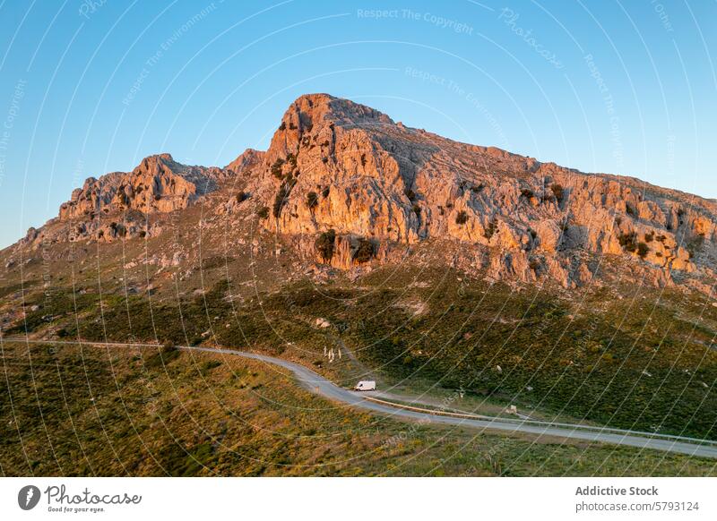 Golden hour over Sardinian mountain landscape sardinia italy golden hour sunlight road car travel serene rugged glow warm nature scenic beauty peaceful island