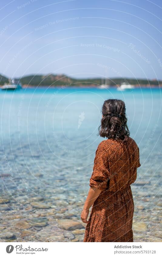 Serene Waterside View in Sardinia, Italy, Grande Pevero Beach woman dress sardinia italy blue water clear distance serenity travel seascape turquoise leisure