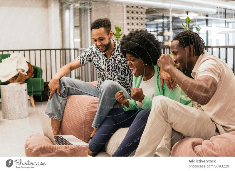 Three colleagues celebrating success in coworking space celebration laptop screen modern office teamwork coworker happy cheer business technology environment