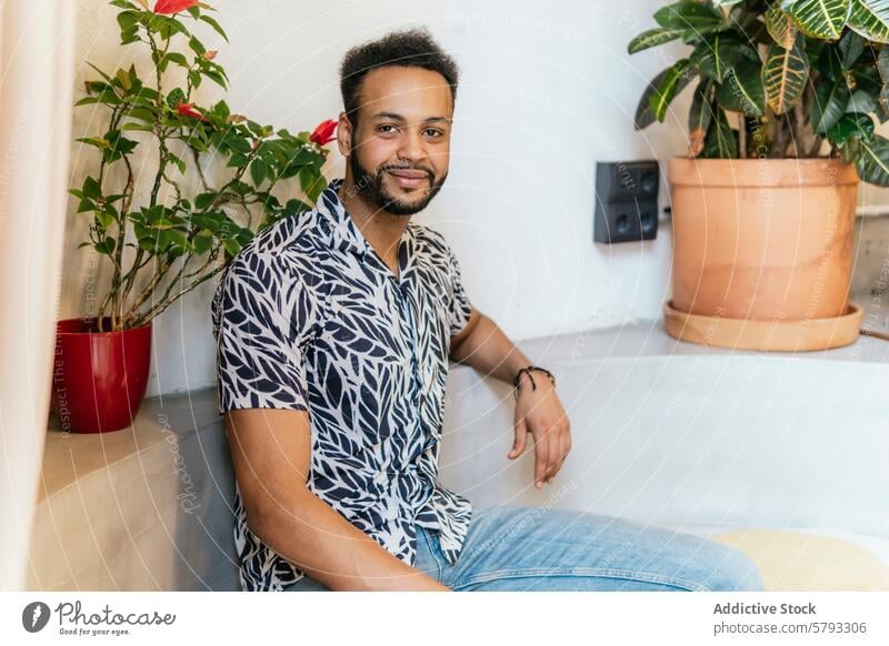 Relaxed young entrepreneur at a modern coworking space casual sitting smile welcoming greenery man workplace freelancer professional comfortable relaxed