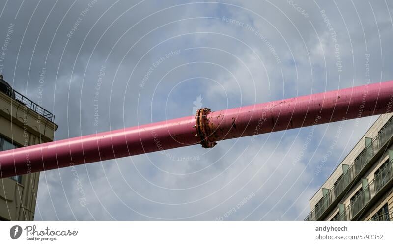 Two houses facing each other in the foreground connected by a pink pipe abstract architecture Berlin building clouds connection constructed construction site